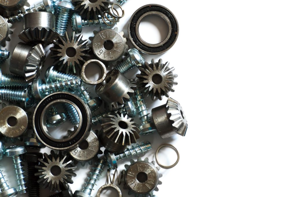 A close-up view of assorted metal gears, screws, and bearings arranged